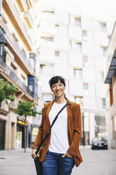 Spanien, Barcelona, lächelnde Geschäftsfrau beim Gehen auf einer Straße - EBSF000605