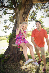 Father playing with daughter at rope swing - TOYF000230