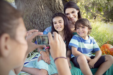 Mädchen fotografiert Mutter mit Kindern am Baum - TOYF000248