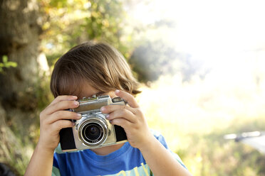 Junge mit Analogkamera beim Fotografieren im Freien - TOYF000252