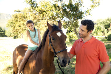 Vater mit Tochter auf Pferd sitzend - TOYF000259
