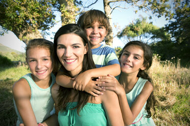 Happy mother with her family outdoors - TOYF000274