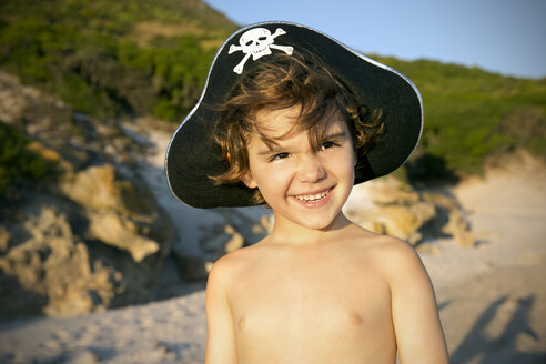 Porträt eines lächelnden Jungen mit Piratenhut am Strand - TOYF000275