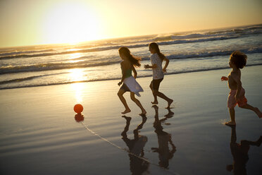 Drei Kinder spielen mit Ball am Strand bei Sonnenuntergang - TOYF000281