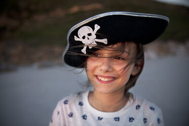 Porträt eines lächelnden Mädchens mit Piratenhut am Strand - TOYF000292