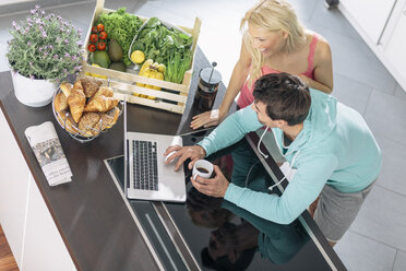 Couple using laptop in the kitchen - MADF000242