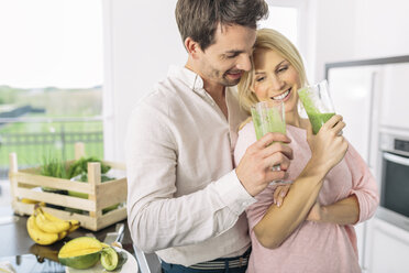 Couple drinking smootie in the kitchen - MADF000291
