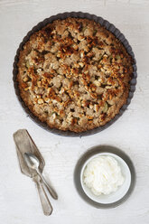 Rhubarb crumble cake in a baking dish and bowl of whipped cream - EVGF001703
