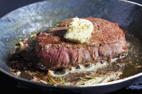 Fried fillet of beef with herb butter, peppercorns and rosemary in a pan - CSF025494