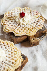 Waffles with whipped cream and cherry on cutting boards - SBDF001832