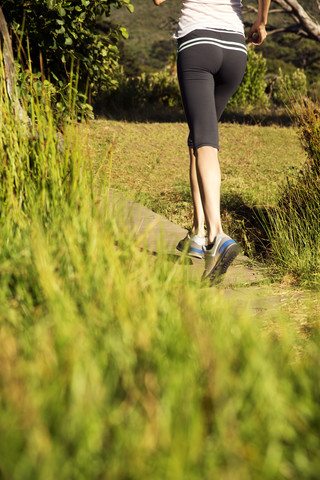Frau joggt in ländlicher Landschaft, lizenzfreies Stockfoto