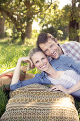 Smiling couple lying on meadow - TOYF000355