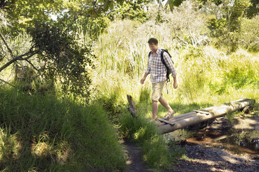 Smiling hiker crossing a brook - TOYF000406