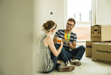 Couple moving house looking at colour samples - UUF004193