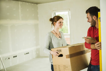 Smiling young couple moving house - UUF004215