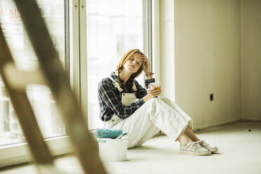 Exhausted young woman having a break from renovating - UUF004241