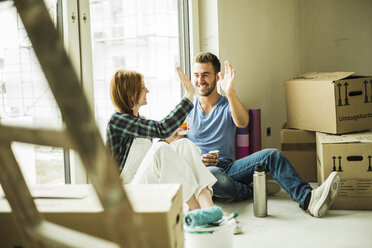 Happy couple having a coffee break from renovating - UUF004246