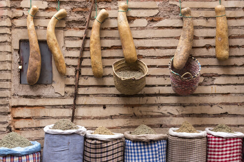 Morocco, Marrakesh, row of calabashes and sacks with spices in front of facade - HSKF000035