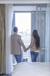 Südafrika, Kapstadt, Rückenansicht eines Paares, das Hand in Hand in einem Hotelzimmer steht - ZEF004689