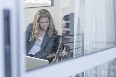 Zwei Frauen beobachten etwas auf einem Laptop - ZEF004695