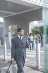 Businessman with suitcase and smartphone - ZEF005842