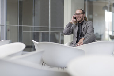 Portrait of businessman telephoning with smartphone - ZEF005852