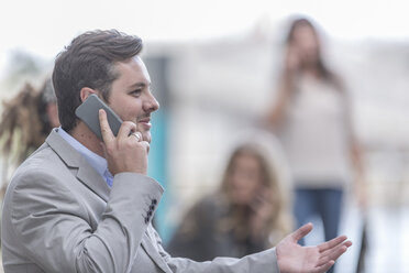 Porträt eines Geschäftsmannes, der mit einem Smartphone telefoniert - ZEF005880