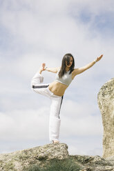 Frau macht Yoga-Übungen auf einem Berg - ABZF000031