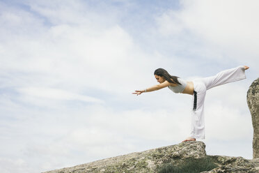 Frau macht Yoga-Übungen auf einem Berg - ABZF000033