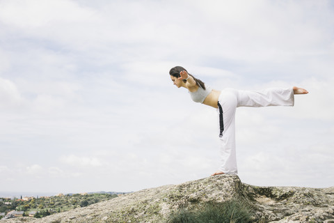 Frau macht Yoga-Übungen auf einem Berg, lizenzfreies Stockfoto