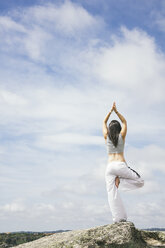 Woman doing yoga exercises on a mountain - ABZF000035