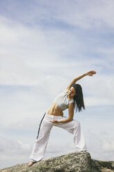 Woman doing yoga exercises on a mountain - ABZF000038