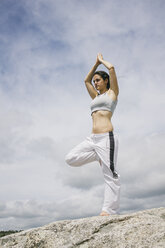 Frau macht Yoga-Übungen auf einem Berg - ABZF000039