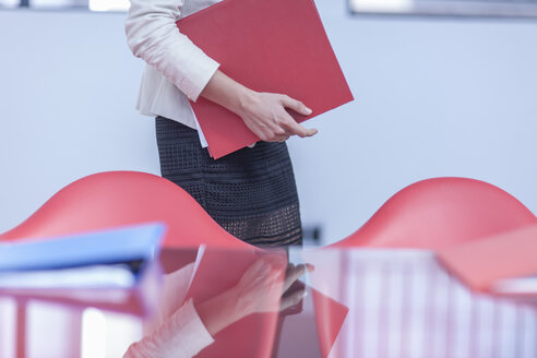 Woman with folders in an office - ZEF005068