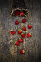 Weidenkorb mit Erdbeeren auf dunklem Holz - LVF003356
