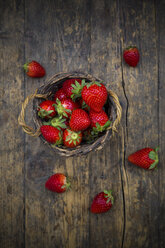 Weidenkorb mit Erdbeeren auf dunklem Holz - LVF003359