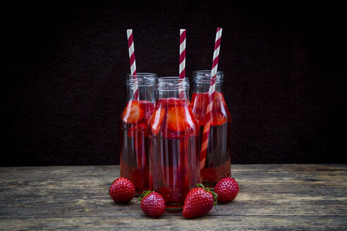 Drei Glasflaschen mit selbstgemachter Erdbeerlimonade - LVF003360