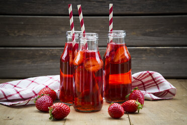 Drei Glasflaschen mit selbstgemachter Erdbeerlimonade - LVF003362
