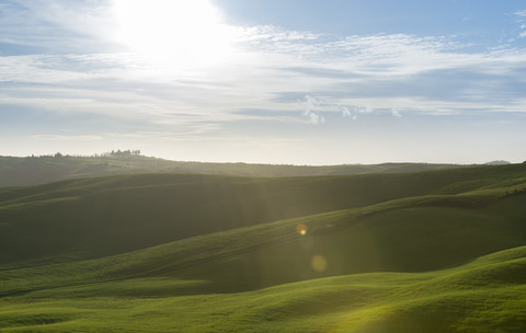 Italien, Toskana, Val d'Orcia, Hügellandschaft bei Gegenlicht, lizenzfreies Stockfoto