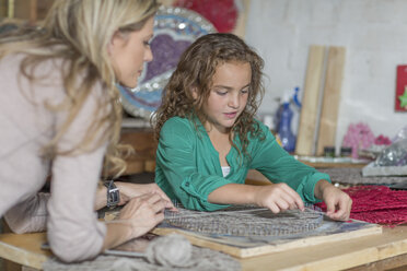 Mother and daughter doing crafts in home garage - ZEF004867