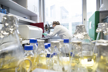 Junge Wissenschaftlerin bei der Arbeit in einem biologischen Labor, Blick in eine Autowerkstatt - SGF001568