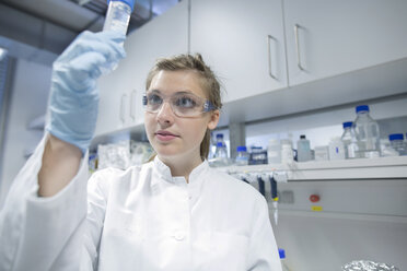 Young female scientist working at biological laboratory inspecting samples - SGF001578