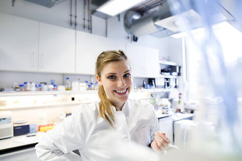 Junge Wissenschaftlerin bei der Arbeit in einem biologischen Labor - SGF001586