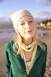 Portrait of smiling young woman on beach - TOYF000425