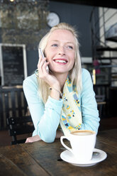 Junge Frau in einem Café am Handy - TOYF000511