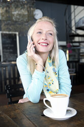 Young woman in a cafe on cell phone - TOYF000511