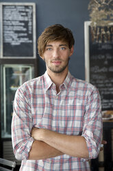 Portrait of confident young man in a cafe - TOYF000519