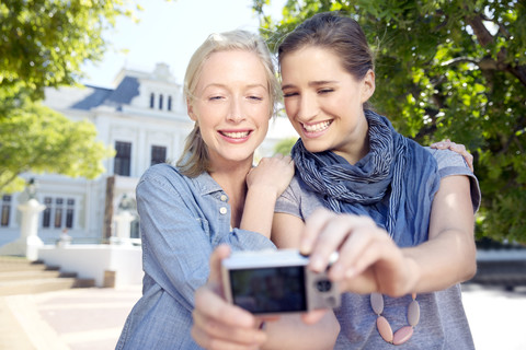 Zwei junge Frauen machen im Freien ein Selfie, lizenzfreies Stockfoto