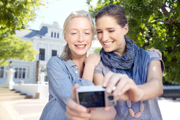 Zwei junge Frauen machen im Freien ein Selfie - TOYF000533