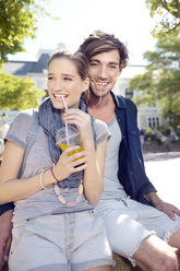 Smiling young couple outdoors with soft drink - TOYF000539